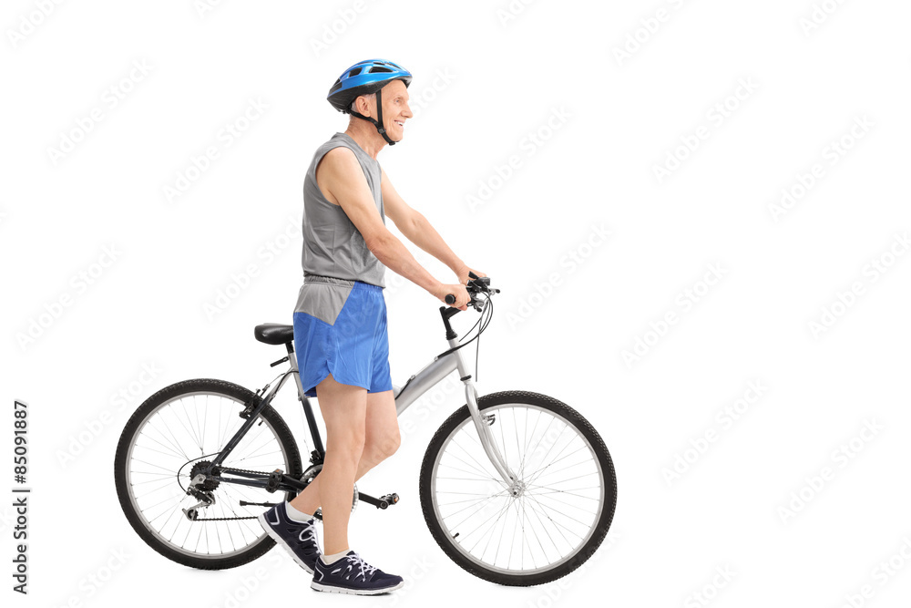 Active senior man pushing a bike Active senior man pushing a bike