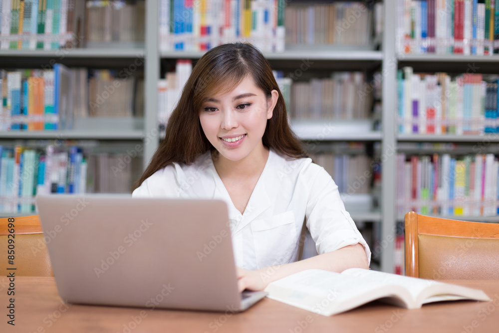 Beautiful asian female student using laptop for study in library Beautiful asian female student using laptop for study in library