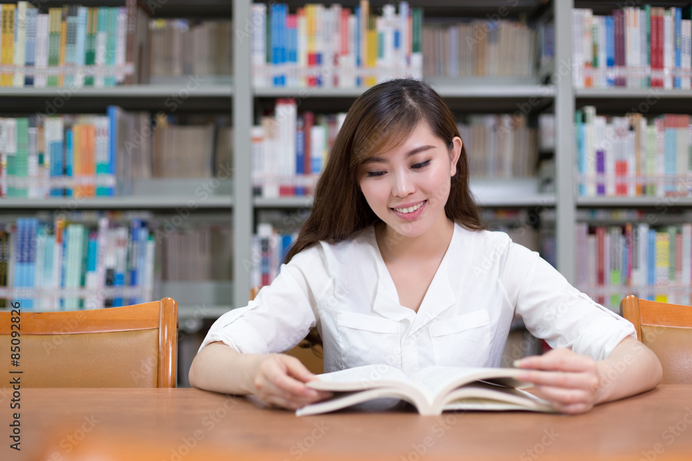Beautiful asian female student read book in library with bookshe Beautiful asian female student read book in library with bookshe