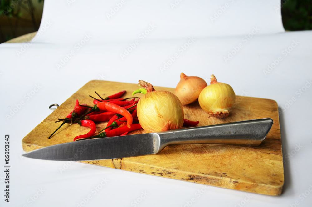 Chili and onion with kitchen tools on white background