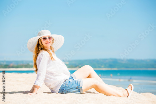 Beautifil young woman lying on the beach at sunny day enjoing