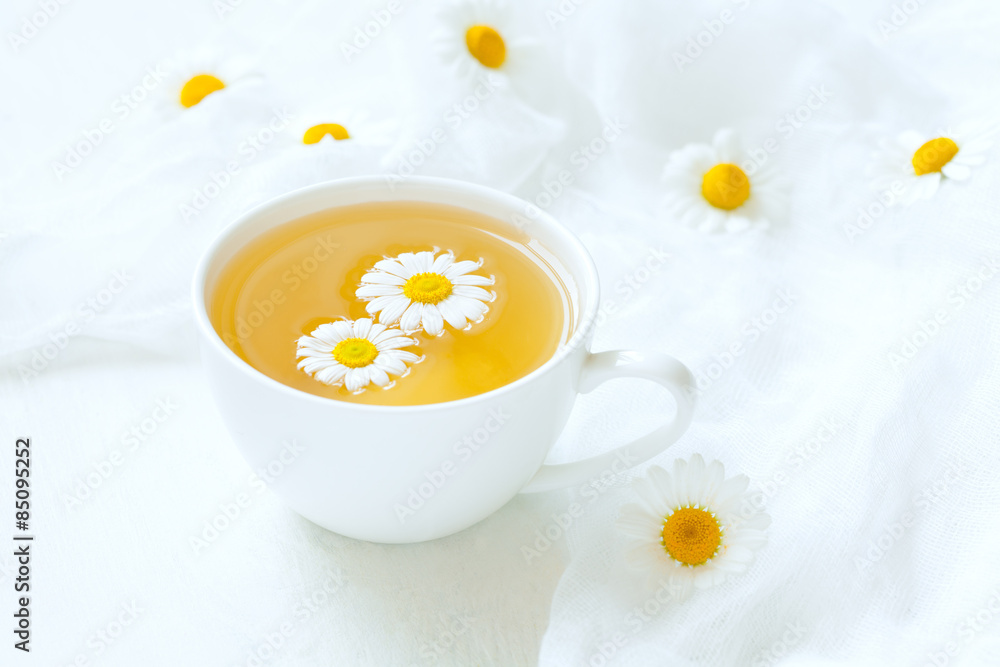 White cup of natural healthy chamomile herb tea with fresh White cup of natural healthy chamomile herb tea with fresh