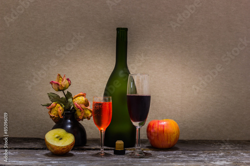 Fototapeta Naklejka Na Ścianę i Meble -  Still life with wine bottle, apple  dry little flower.