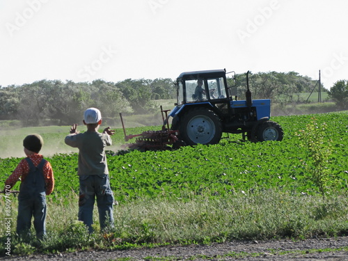 children look  on a tractor