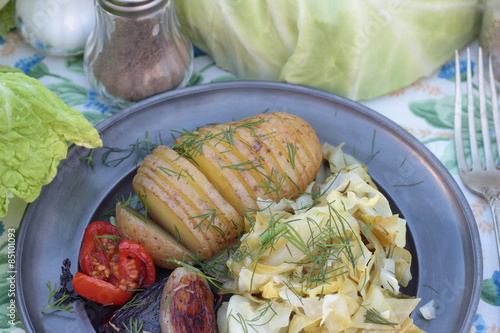 Closeup of cooked cabbage and roasted concertina potato.