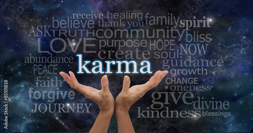 Cosmic Karma - Female hands cupped upwards with the word 'Karma' floating away surrounded by a relevant word cloud on a deep space night sky dark blue  background 