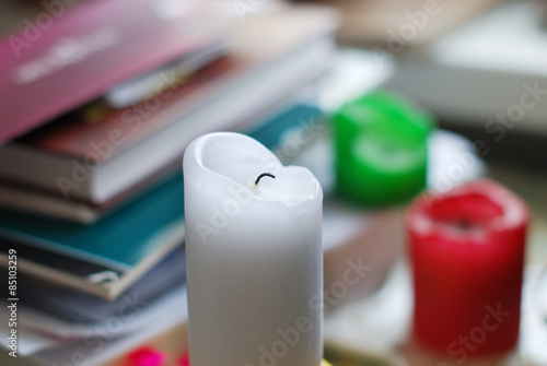 The calcine white candle on a background of books