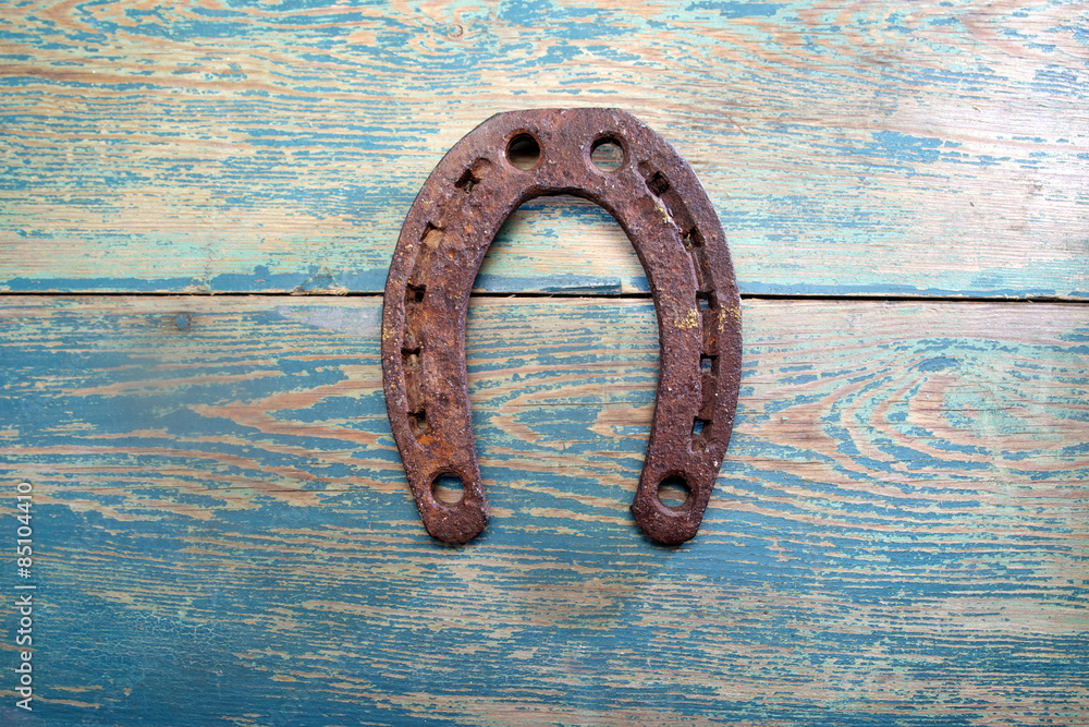 Old iron rusty metal horseshoe on weathered wood Old iron rusty metal horseshoe on weathered wood