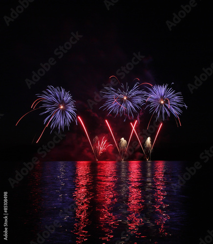 Colorful fireworks with reflection on lake.