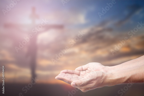Praying Hand and the cross blurred background