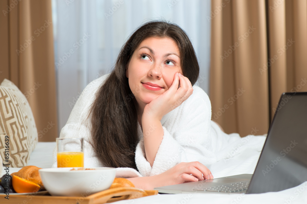 smiling dreamy girl with laptop and breakfast smiling dreamy girl with laptop and breakfast