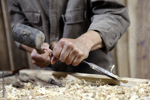 Foto hands of carpenter with a hammer and chisel on the workbench in carpentry
