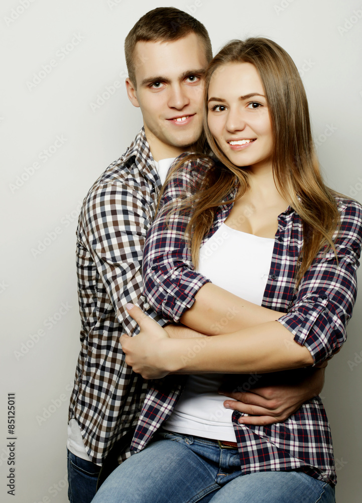 lovely happy couple hugging over grey background. lovely happy couple hugging over grey background.