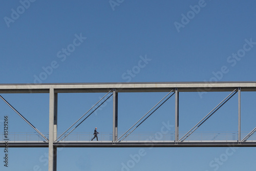 businessman walking over bridge 
