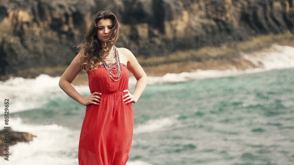 Portrait of serious, pretty woman standing on rocks near sea, slow motion shot at 240fps
Portrait of serious, pretty woman standing on rocks near sea, slow motion shot at 240fps
