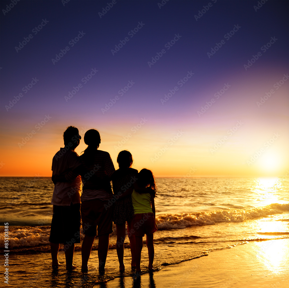 happy family watching the sunset on the beach