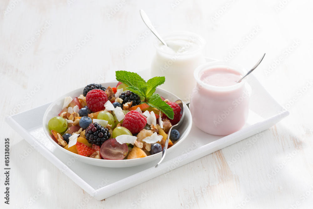 fruit salad and various yoghurt on a white wooden table fruit salad and various yoghurt on a white wooden table