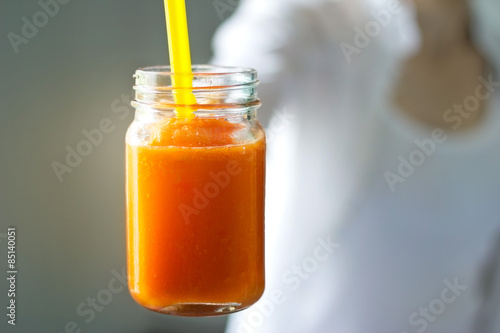 Fresh smoothie detox vegetable carrot in hand on vintage color tone