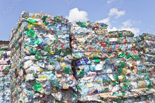 Stack of plastic bottles for recycling against blue sky