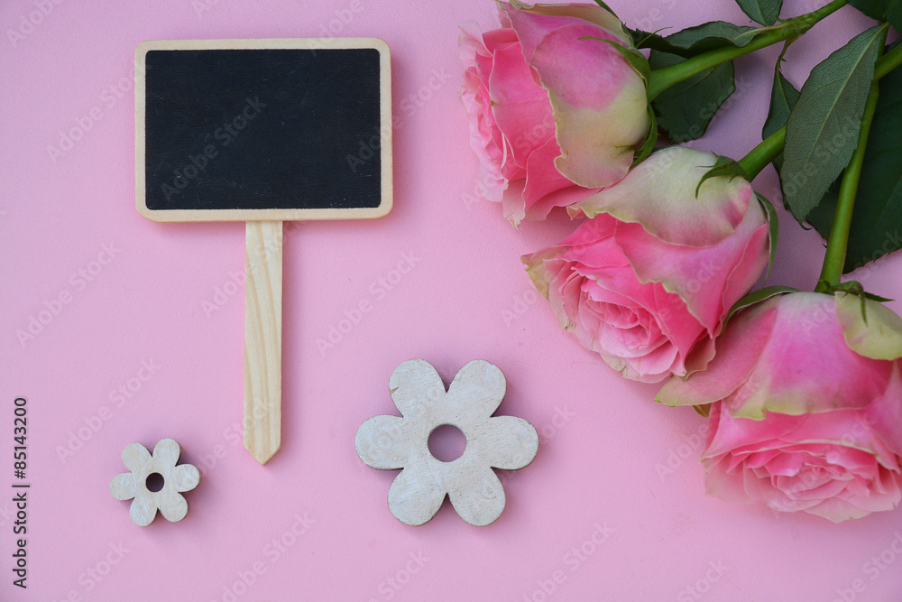 Pink painted wooden background with empty black chalk board and pink roses and flower decoration Pink painted wooden background with empty black chalk board and pink roses and flower decoration