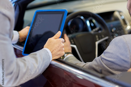 close up of men with tablet pc in car salon