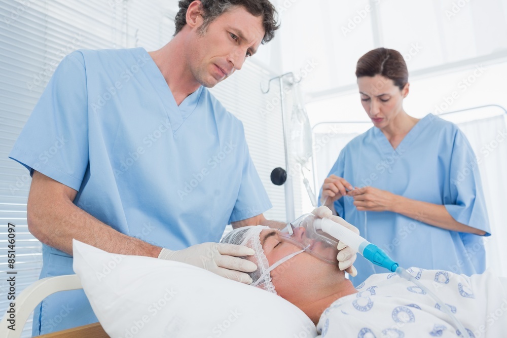 Obraz premium Doctors holding oxygen mask and examining intravenous drip