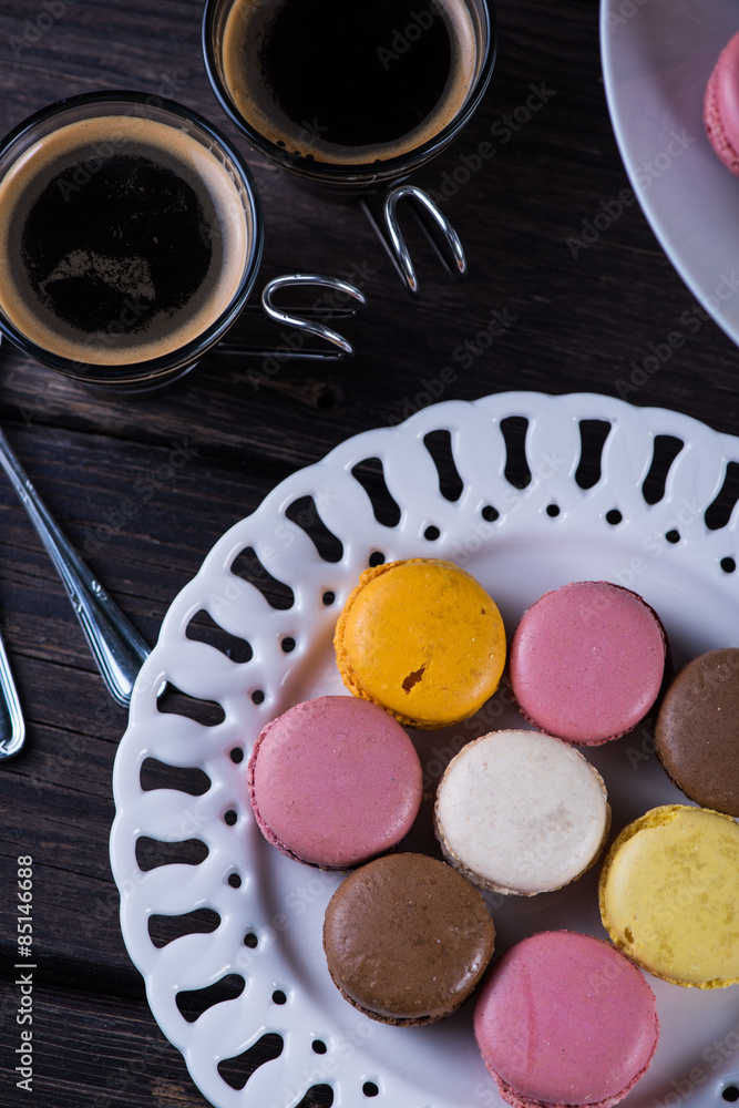 Fresh vibrant macaroons on plate with coffee Fresh vibrant macaroons on plate with coffee