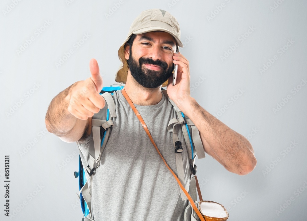 Backpacker talking to mobile over white background Backpacker talking to mobile over white background