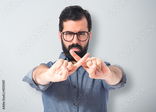 Young hipster man doing NO gesture photo