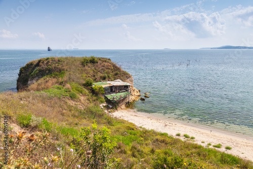 Wild beach with small abandoned restaurant photo
