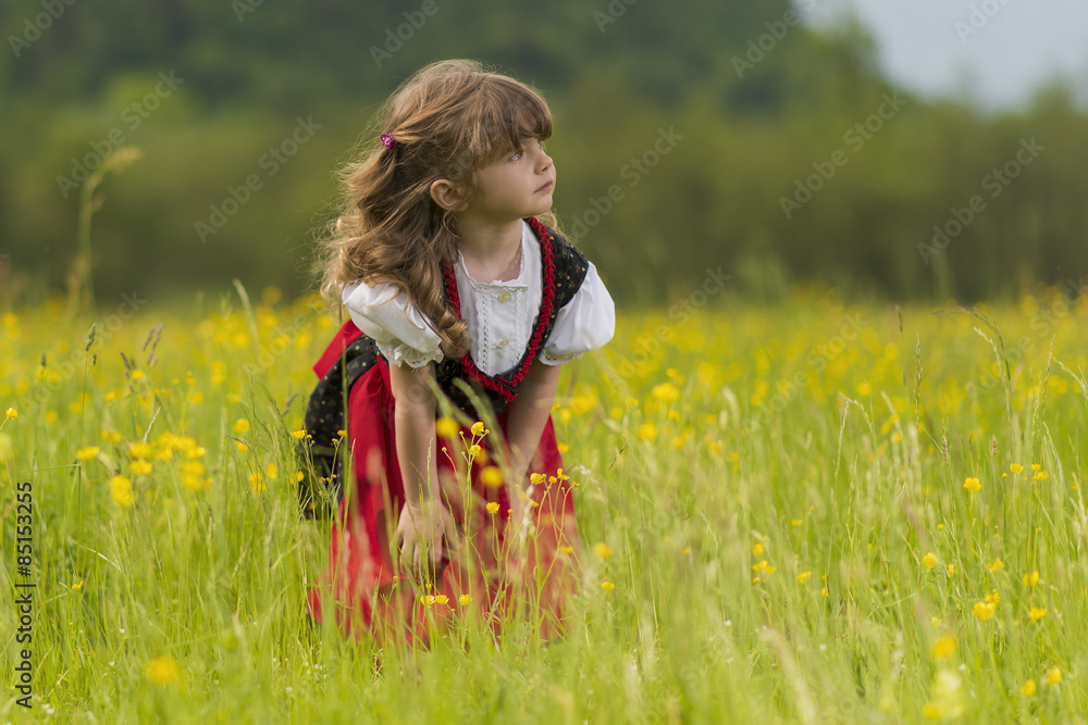 Bambina bionda nel campo di fiori