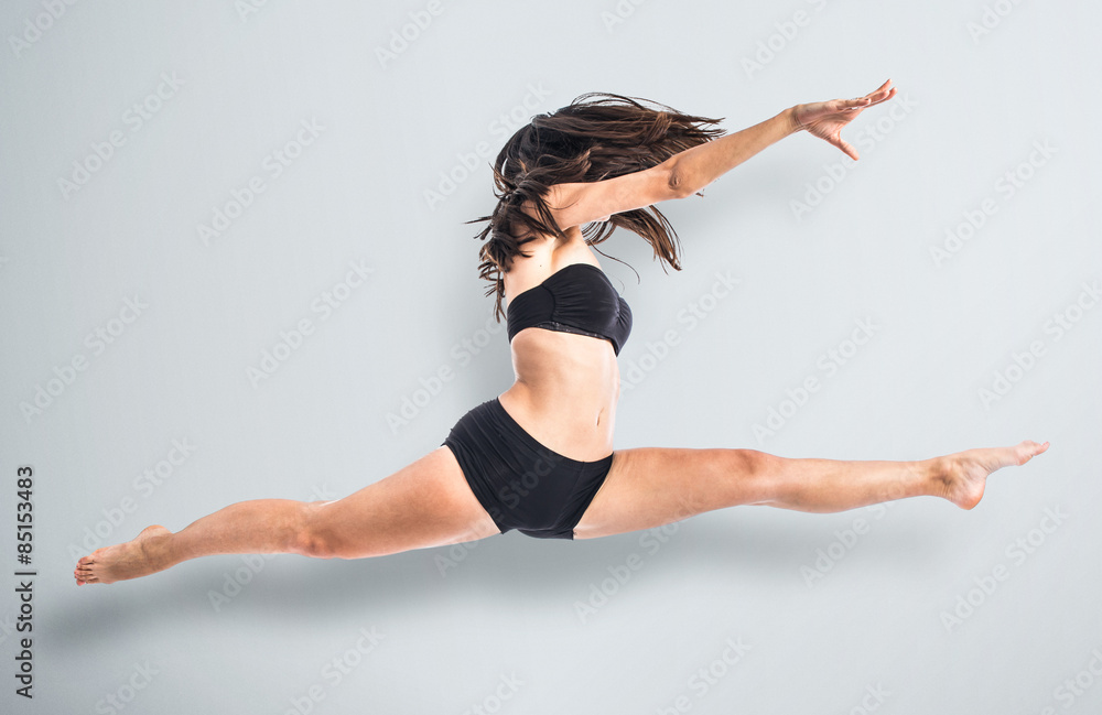 Young ballet dancer jumping over white background