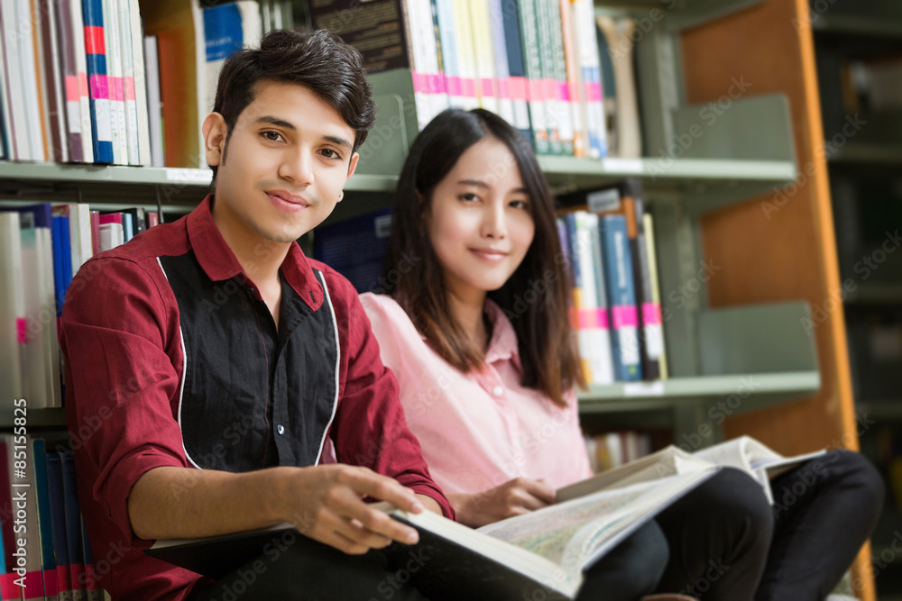 Asian male and female students reading at library Asian male and female students reading at library