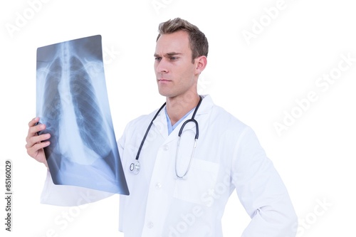 Serious young doctor looking at x-ray