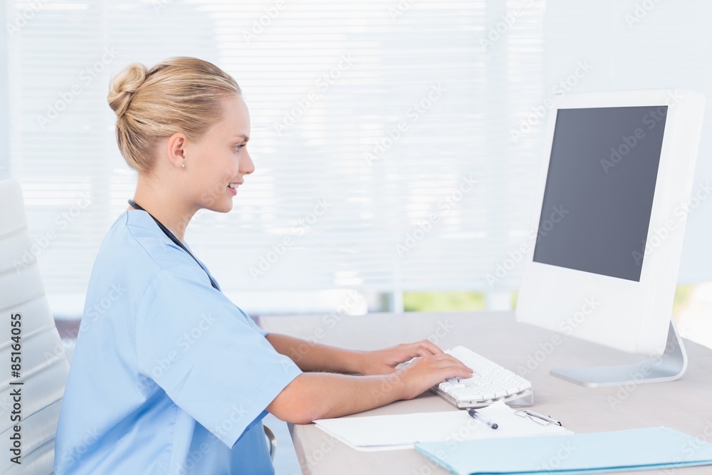 Smiling nurse using computer Smiling nurse using computer