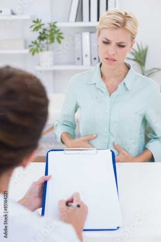 Patient with stomach ache speaking with her doctor  photo