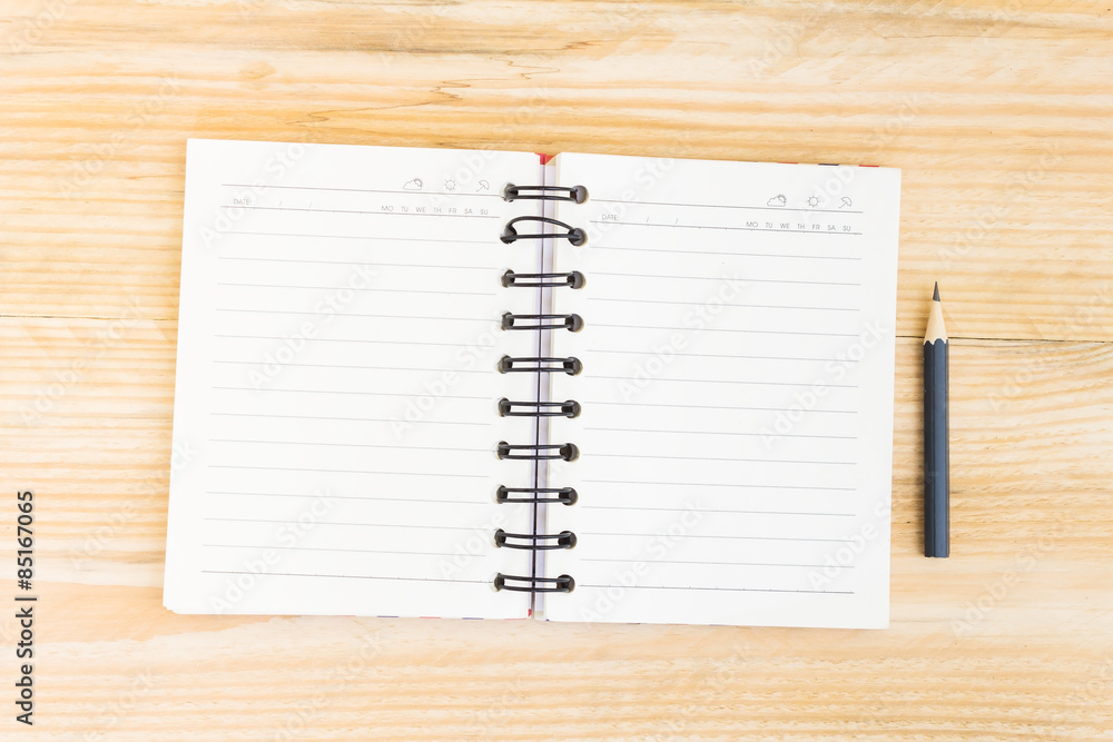 Blank open notebook with black pencil on wood table,Business tem Blank open notebook with black pencil on wood table,Business tem
