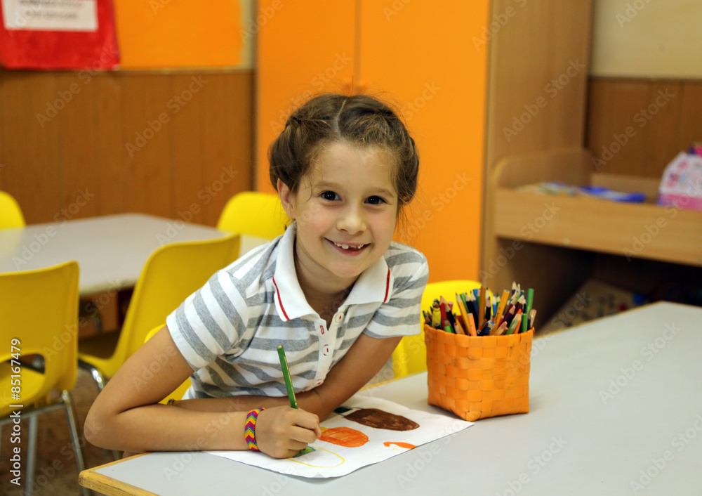 pretty little girl while drawing with the pencil colours at scho pretty little girl while drawing with the pencil colours at scho