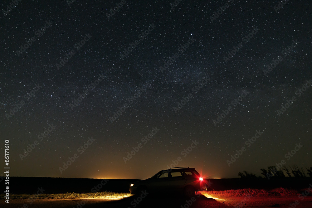 The car with the headlights switched on the background of the Mi