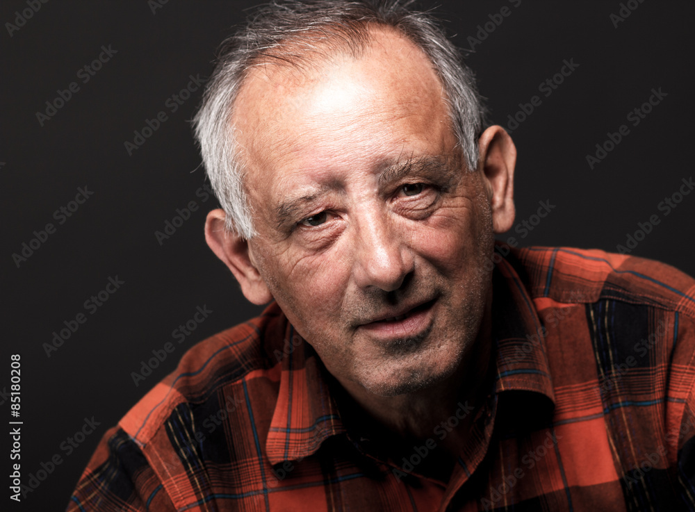 Obraz premium Portrait of senior man looking at camera on black background