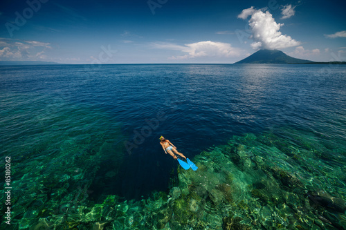 Photography Lady snorkeling over reef wall