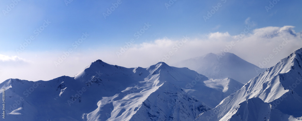 Panorama of snowy mountains in early morning fog Panorama of snowy mountains in early morning fog
