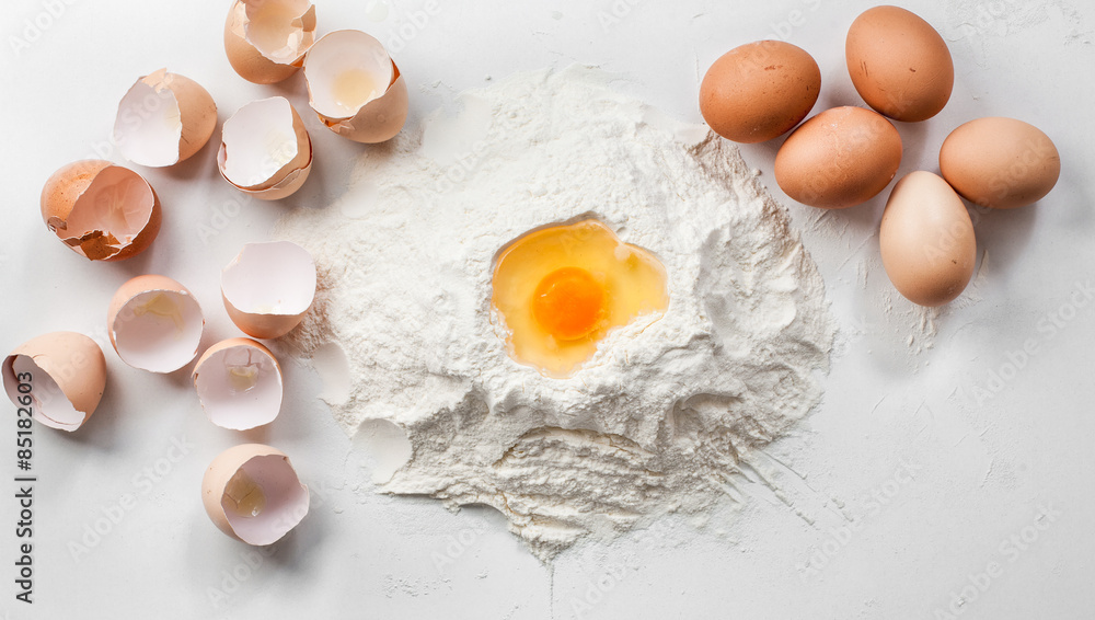white background with eggs , shells and flour white background with eggs , shells and flour