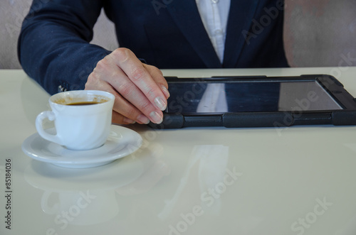 hand and tablet..typing message into mobile