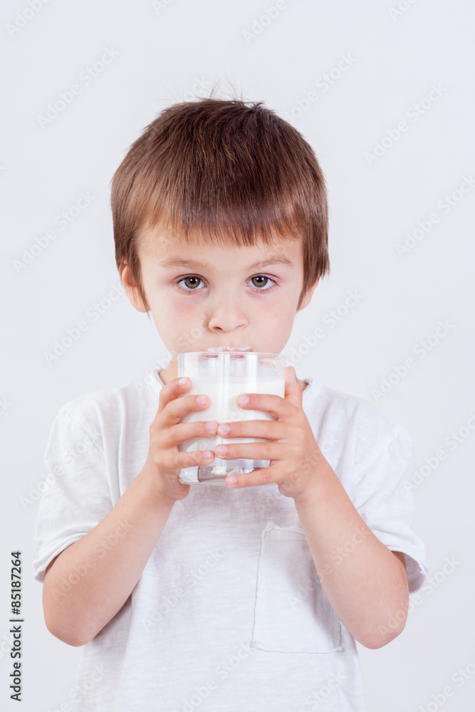 Cute little boy, drinking milk, holding glass of milk, mustaches Cute little boy, drinking milk, holding glass of milk, mustaches
