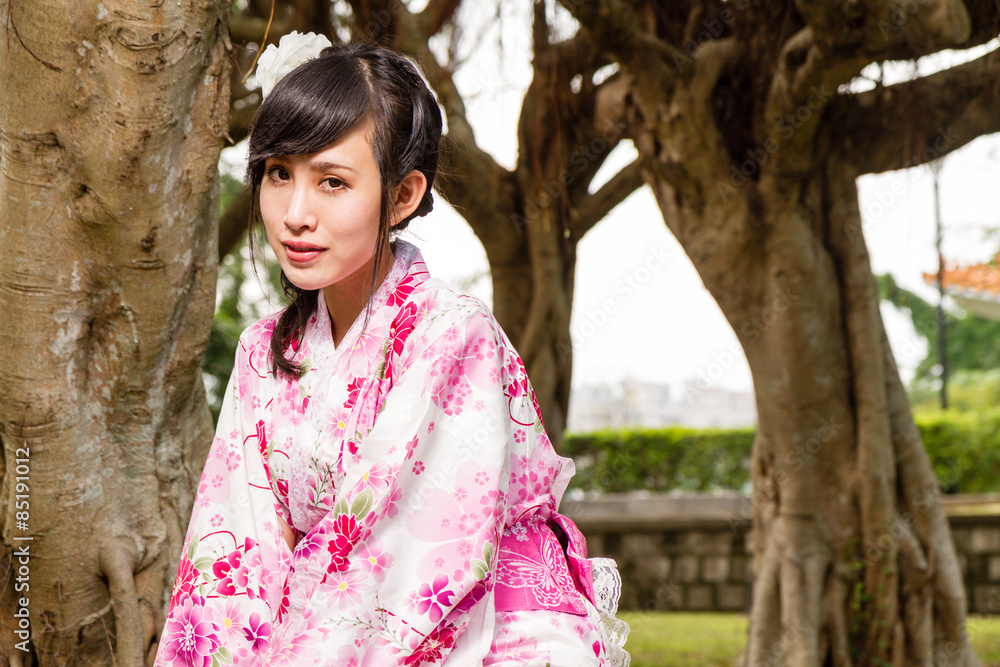 Asian woman in kimono in garden Asian woman in kimono in garden