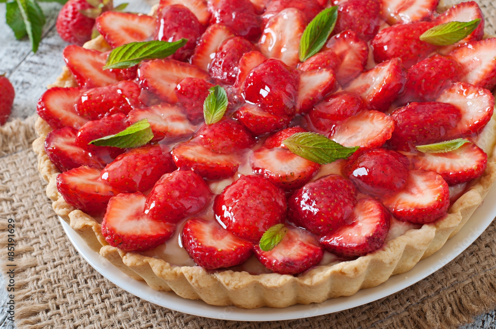 Tart with strawberries and whipped cream decorated with mint leaves Tart with strawberries and whipped cream decorated with mint leaves
