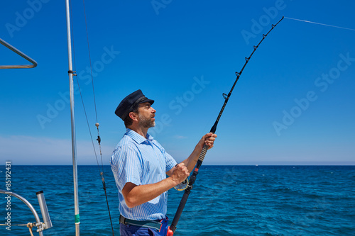 Beard sailor man fishing rod trolling in saltwater