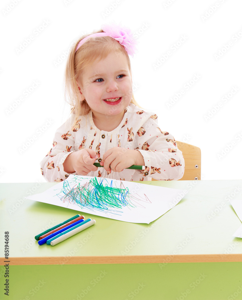Smiling girl draws markers on a sheet of paper sitting at the D Smiling girl draws markers on a sheet of paper sitting at the D
