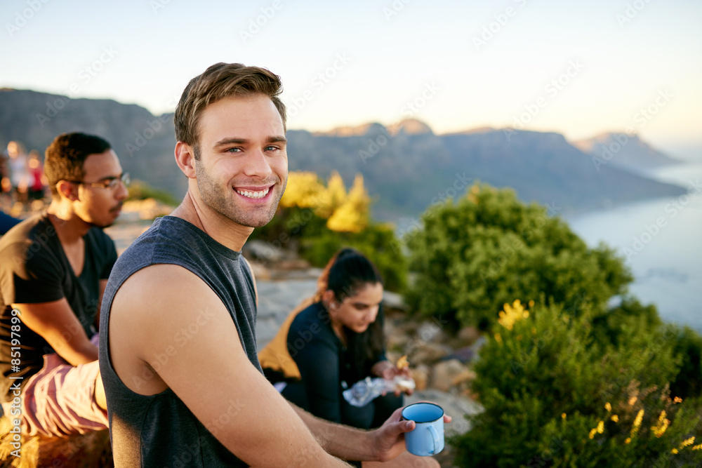 Young guy having a cup of coffee on a hike Young guy having a cup of coffee on a hike